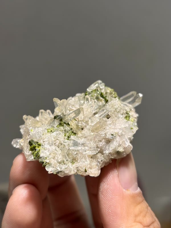 Clear quartz needles with dark green epidote from Sichuan, China, close-up of the crystal faces