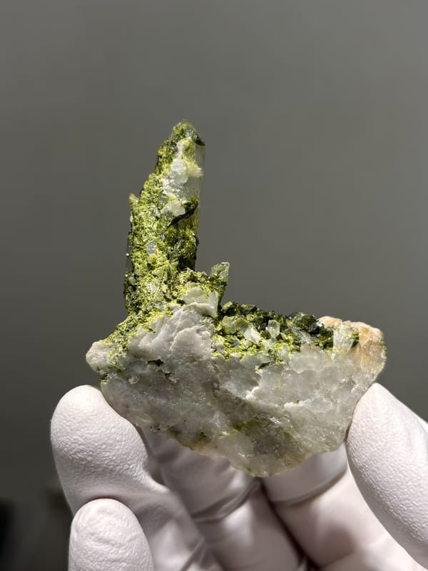Clear quartz point rising from green epidote from Sichuan, China, close-up of the crystal faces