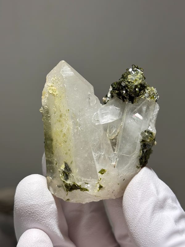Milky quartz point on dark green epidote base from Sichuan, China, close-up of the crystal faces