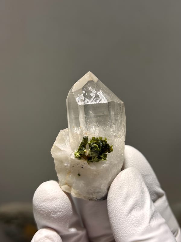 Clear quartz point on green epidote base from Sichuan, China, close-up of the crystal faces