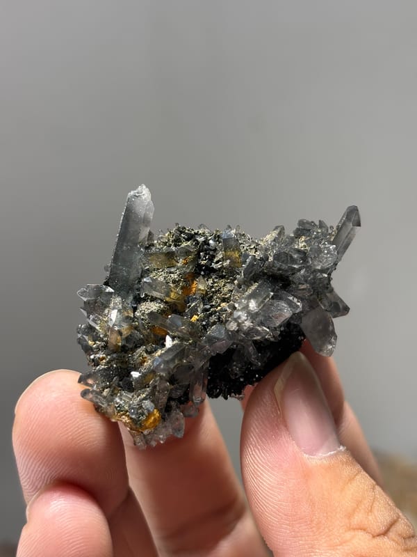 Grey quartz cluster with epidote and orange flecks from Yunnan, China, second angle