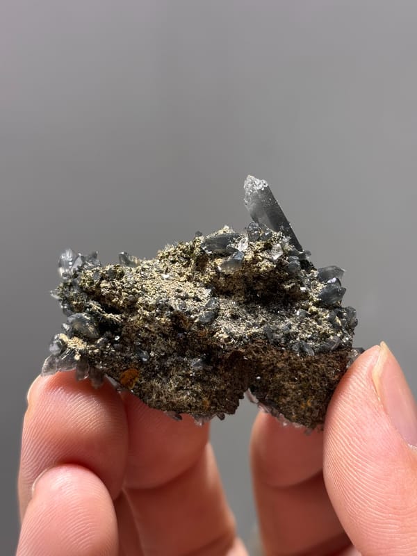 Grey quartz cluster with epidote and orange flecks from Yunnan, China, reverse side