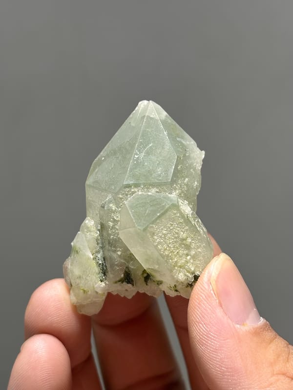 Pale green epidote quartz floater with complete tip from Sichuan, China, held in hand