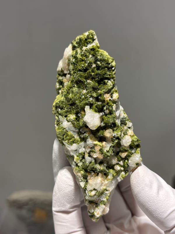 Block of green epidote with white quartz from Sichuan, China, close-up of the crystal faces