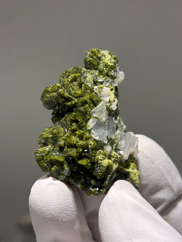 Olive-green epidote cluster with white-capped quartz from Sichuan, China, close-up of the crystal faces
