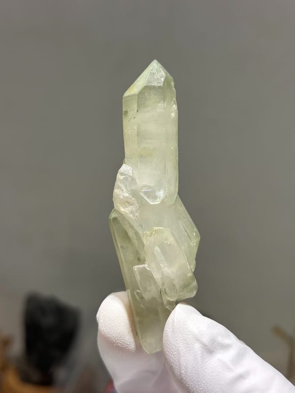 Pale green epidote-tinted quartz wand from Sichuan, China, close-up of the crystal faces