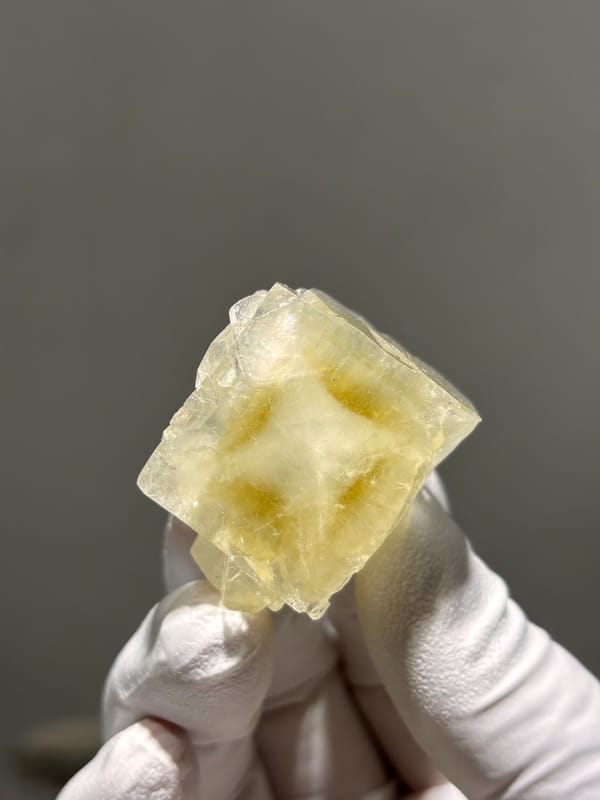 Pale yellow apophyllite cube with hourglass pattern from India, close-up of the crystal faces