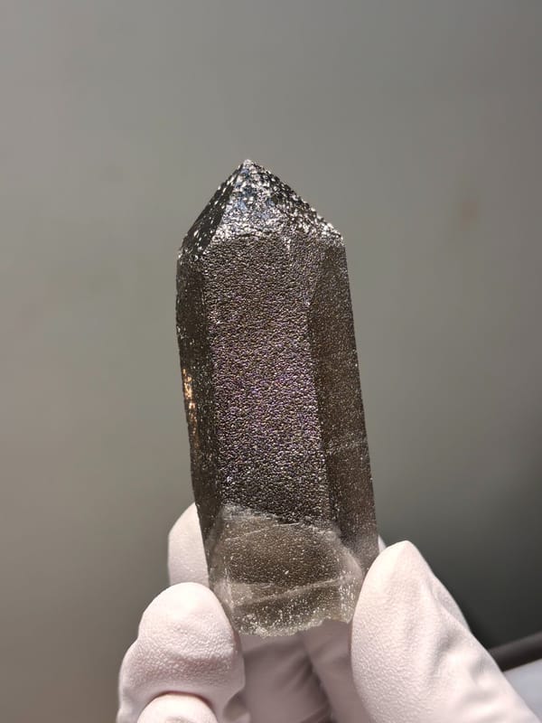 Dark smoky quartz point with sparkling flecks from Fujian, China, close-up of the crystal faces