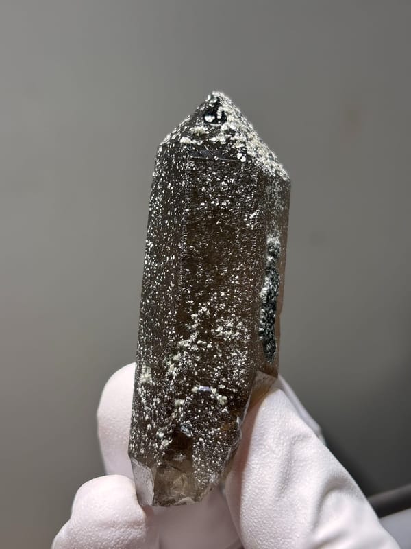 Dark smoky quartz point with mica-dusted tip from Fujian, China, close-up of the crystal faces