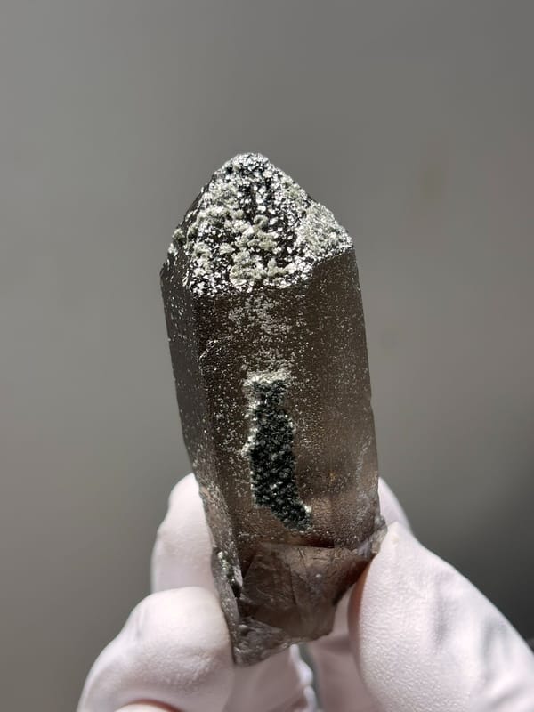 Dark smoky quartz point with mica-dusted tip from Fujian, China, side view