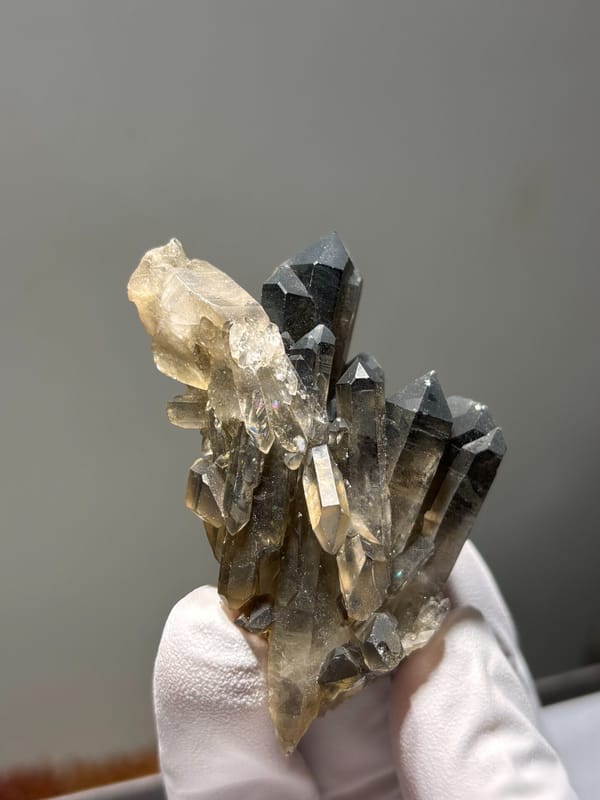 Smoky quartz cluster with pale side crystals from Sichuan, China, close-up of the crystal faces