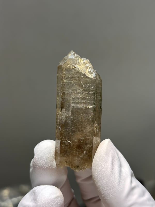 Tea-brown smoky quartz point with milky tip from Sichuan, China, close-up of the crystal faces