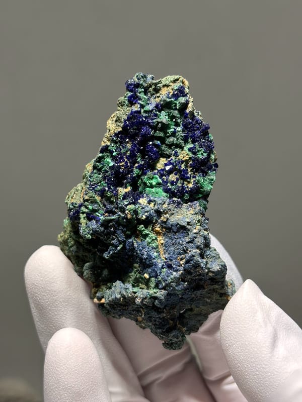 Deep blue azurite plate with green malachite from Hubei, China, held in gloved hand