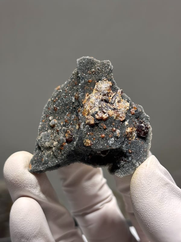 Red-brown sphalerite crystals on dark matrix from Hebei, China, close-up of the crystal faces
