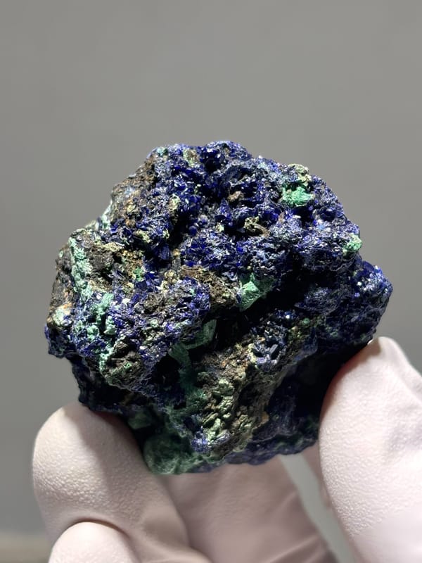 Sparkling azurite nodule with green malachite from Hubei, China, close-up of the crystal faces