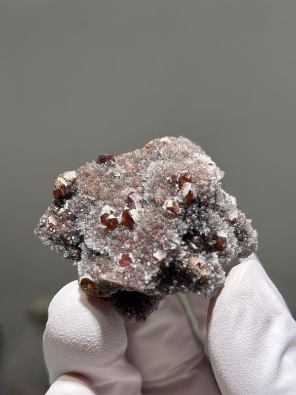 Red-brown sphalerite crystals on white quartz druse from Hubei, China, close-up of the crystal faces