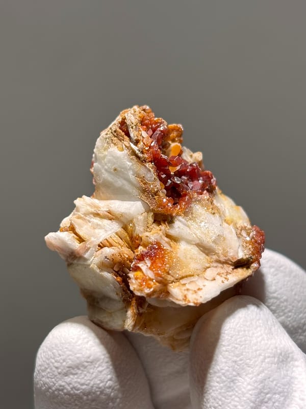 Red vanadinite crystals on white baryte from Morocco, close-up of the crystal faces