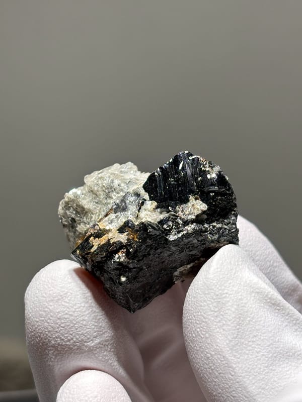 Black cassiterite block with silver mica from Xuebaoding, Sichuan, China, close-up of the crystal faces