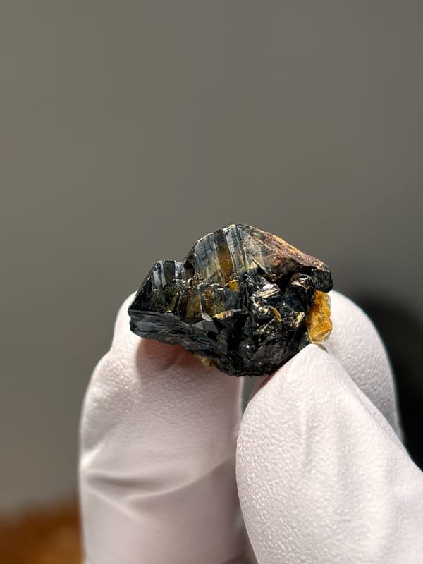 Tiny black cassiterite with golden mica from Xuebaoding, Sichuan, China, second angle