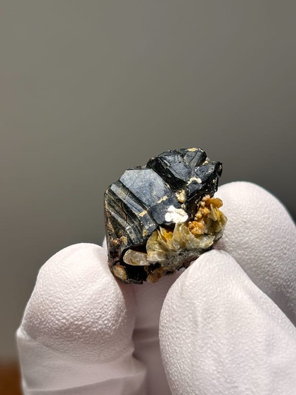 Tiny black cassiterite with golden mica from Xuebaoding, Sichuan, China, reverse side