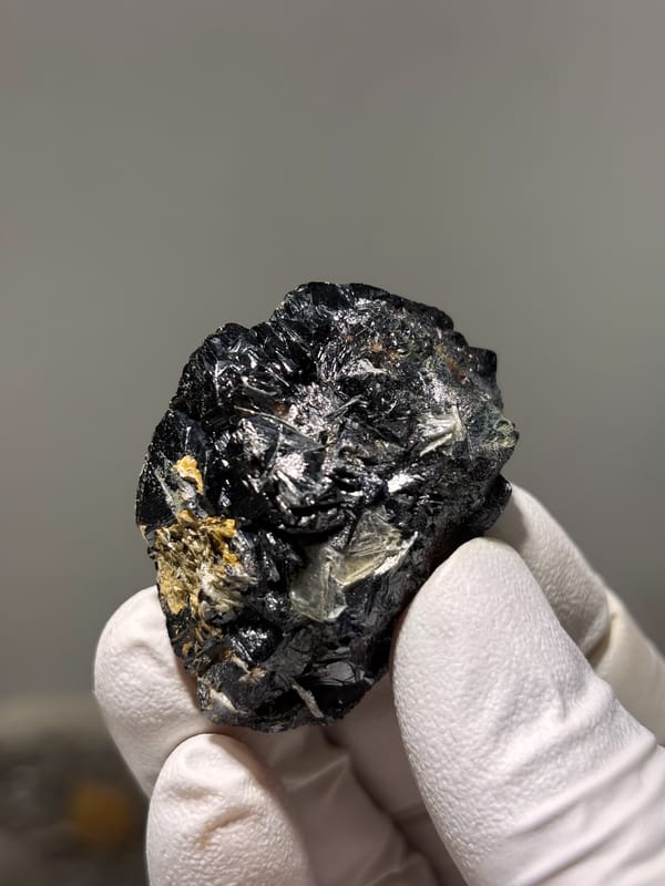 Black cassiterite crystal group with mica from Xuebaoding, Sichuan, China, close-up of the crystal faces