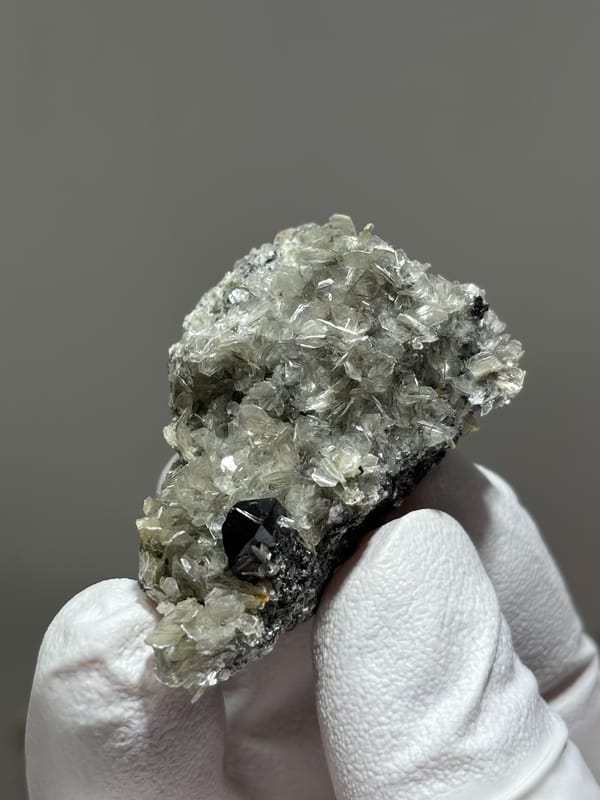 Black cassiterite crystal in pale mica from Xuebaoding, Sichuan, China, second angle