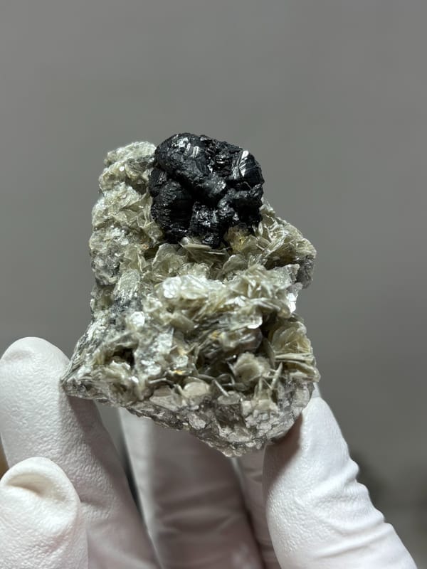 Black cassiterite crystal on tan mica from Xuebaoding, Sichuan, China, second angle