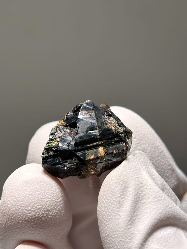 Tiny black cassiterite with iridescent sheen from Xuebaoding, Sichuan, China, second angle