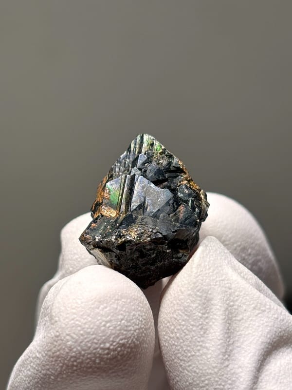 Tiny black cassiterite with iridescent sheen from Xuebaoding, Sichuan, China, reverse side