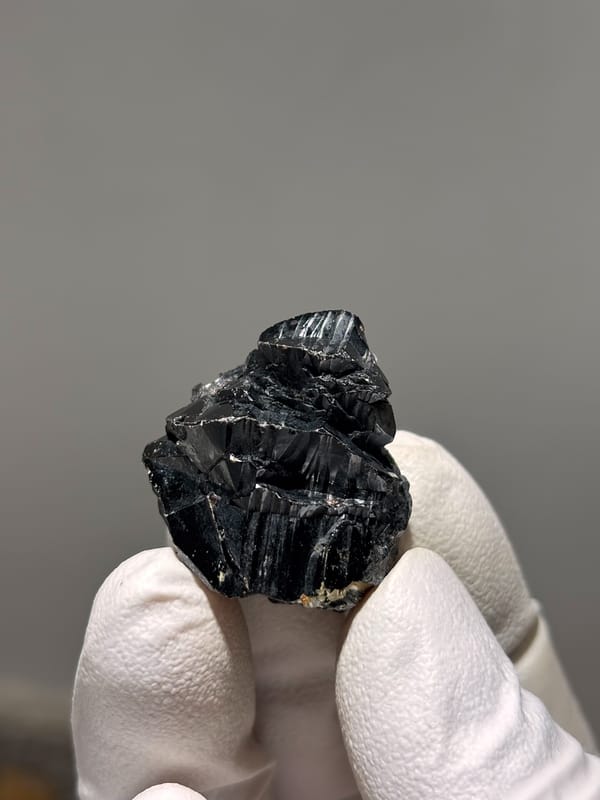 Black cassiterite crystal with bright faces from Xuebaoding, Sichuan, China, close-up of the crystal faces