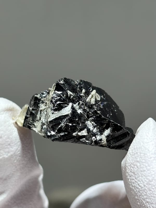 Glossy black cassiterite crystal with mica from Xuebaoding, Sichuan, China, second angle
