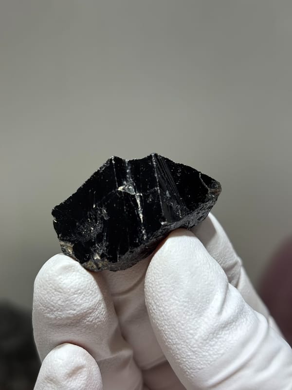 Glossy black cassiterite crystal from Xuebaoding, Sichuan, China, close-up of the crystal faces