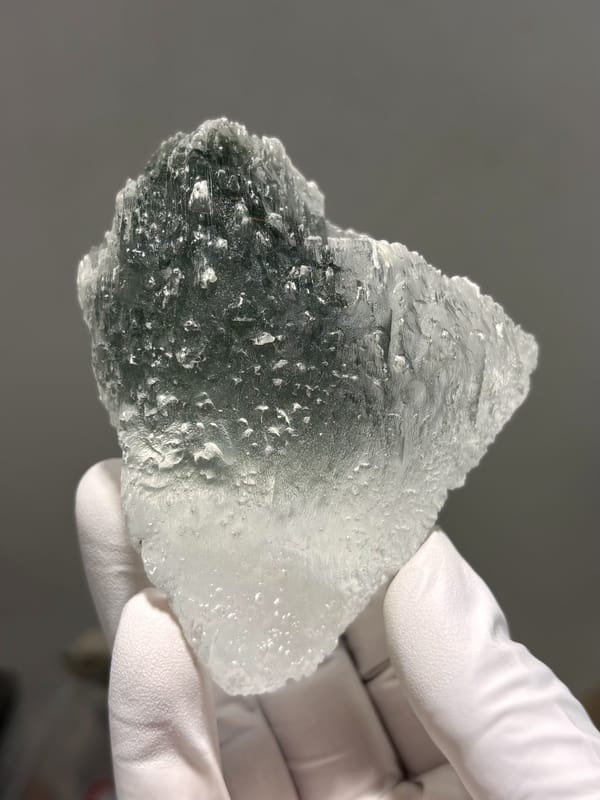 Gypsum floater plate with green chlorite faces from Pakistan, held in gloved hand