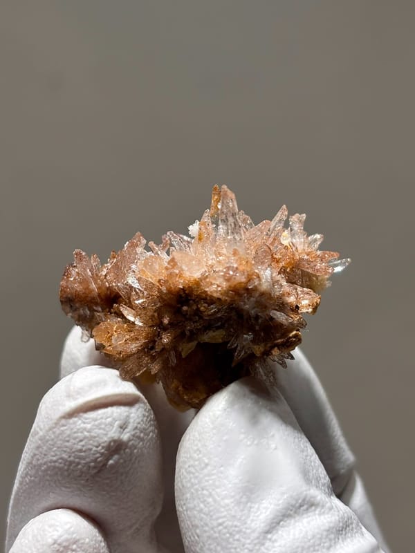 Spray of peach gypsum needles from Guizhou, China, close-up of the crystal faces