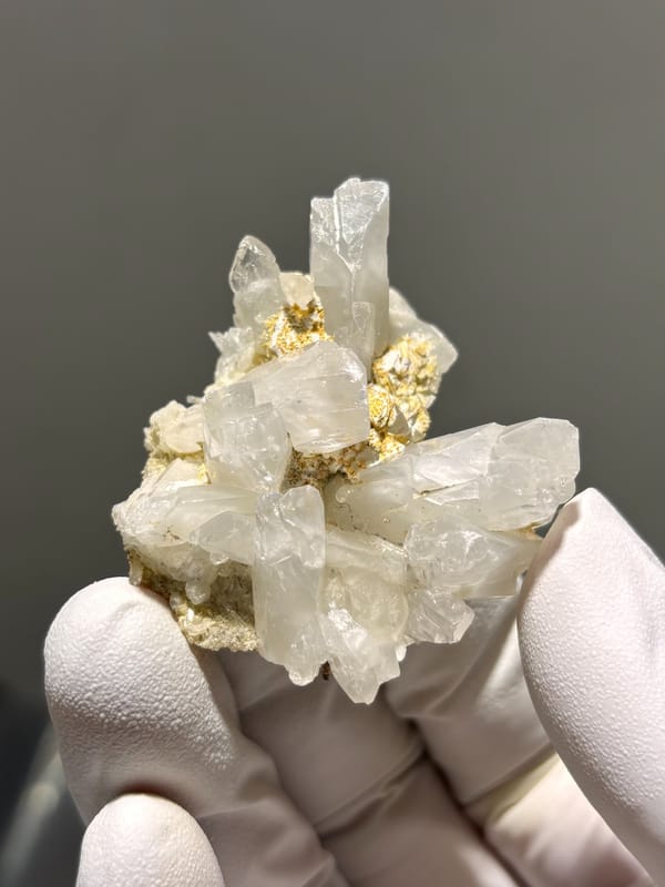 Cluster of clear baryte blades with golden staining from Sichuan, China, close-up of the crystal faces