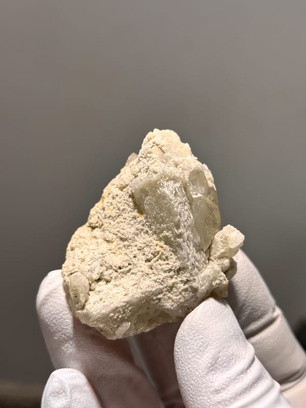 Cream baryte crystal in sandy matrix from Sichuan, China, close-up of the crystal faces