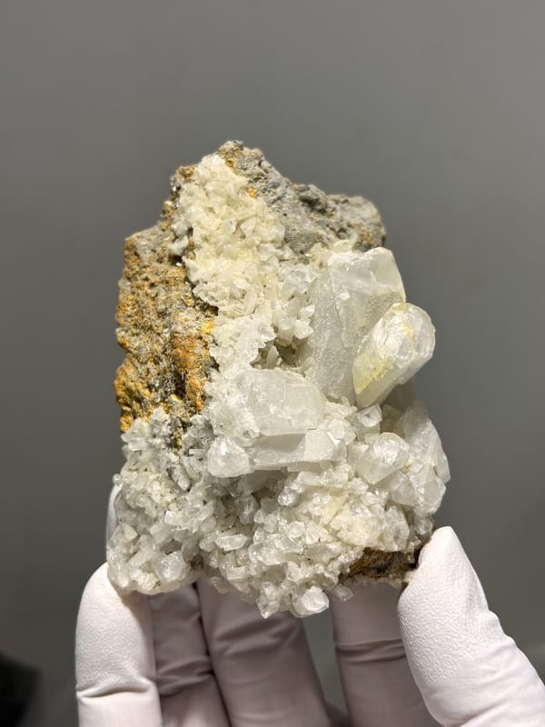 Plate of cream baryte crystals on golden matrix from Sichuan, China, close-up of the crystal faces