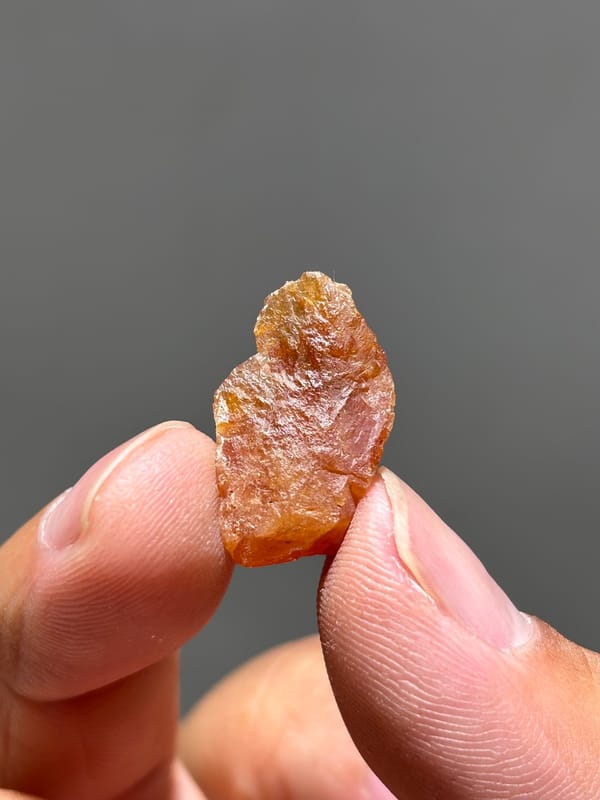 Tiny bright orange scheelite crystal from Xuebaoding, Sichuan, China, close-up of the crystal faces
