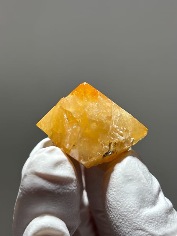 Bright orange scheelite floater crystal from Xuebaoding, Sichuan, China, close-up of the crystal faces