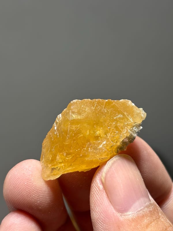 Golden-orange scheelite with floater faces from Xuebaoding, Sichuan, China, held in hand