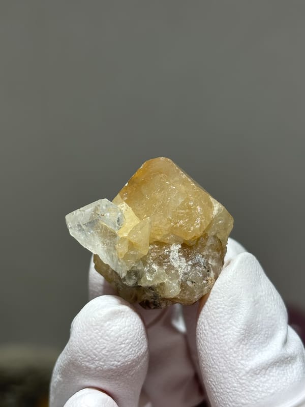 Honey scheelite with small clear aquamarine from Xuebaoding, Sichuan, China, close-up of the crystal faces
