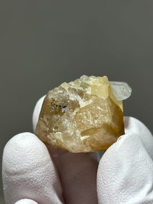 Honey scheelite with small clear aquamarine from Xuebaoding, Sichuan, China, top view