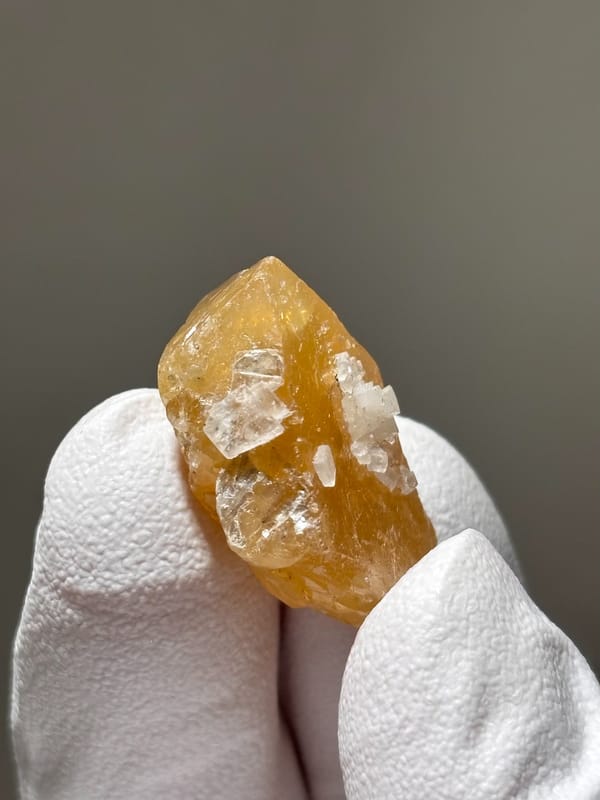 Small honey scheelite with white calcite spots from Xuebaoding, Sichuan, China, second angle
