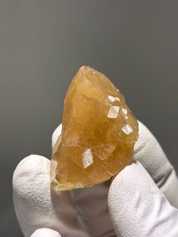 Honey scheelite with white calcite specks from Xuebaoding, Sichuan, China, second angle