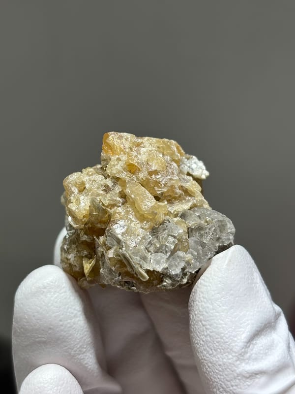 Honey scheelite with clear fluorite from Xuebaoding, Sichuan, China, close-up of the crystal faces