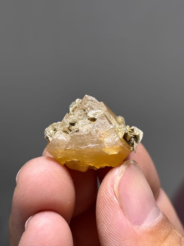 Honey scheelite floater with mica from Xuebaoding, Sichuan, China, close-up of the crystal faces