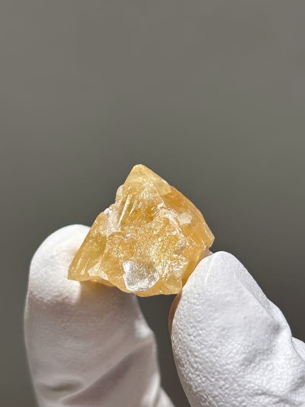 Small honey scheelite crystal with mica from Xuebaoding, Sichuan, China, second angle