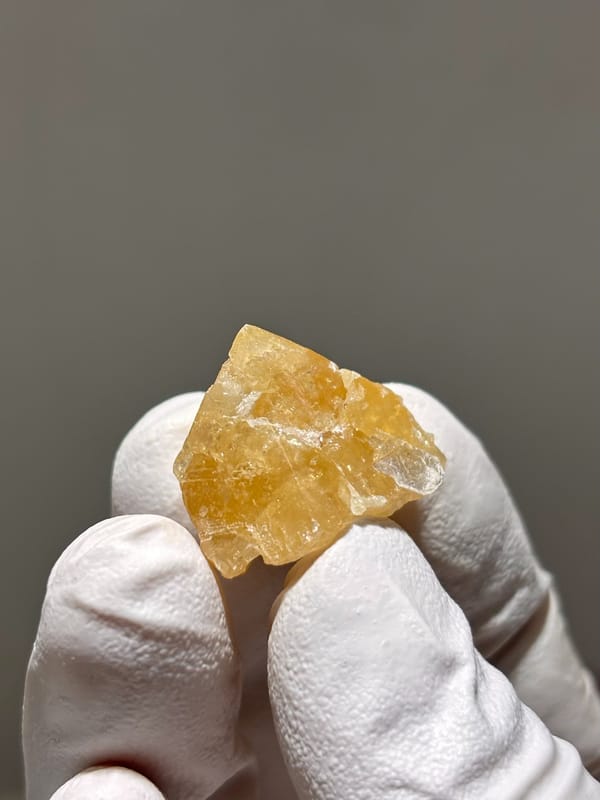 Small honey scheelite crystal with mica from Xuebaoding, Sichuan, China, close-up of the crystal faces