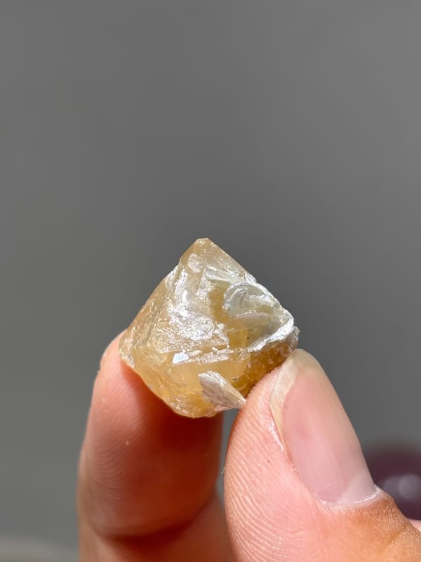 Small honey scheelite with mica from Xuebaoding, Sichuan, China, reverse side
