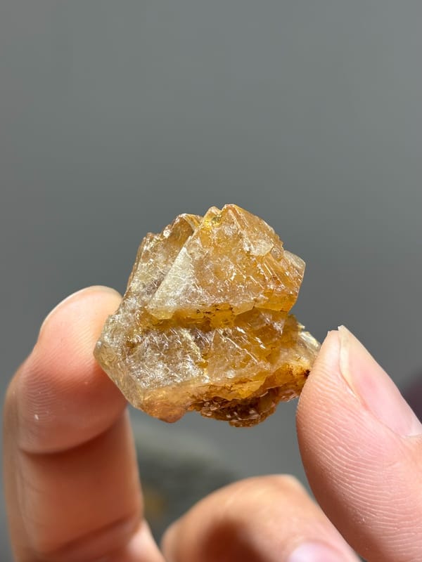 Honey scheelite floater group with mica from Xuebaoding, Sichuan, China, held in hand